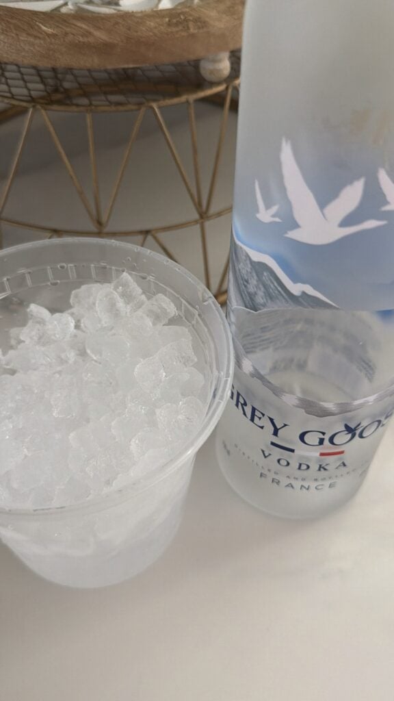 A cup of ice and a bottle of Grey Goose Vodka