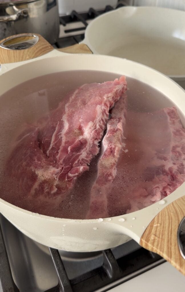 Ribs with the thin membrane removed from the back of pork ribs before cooking and in a pot of boiling water