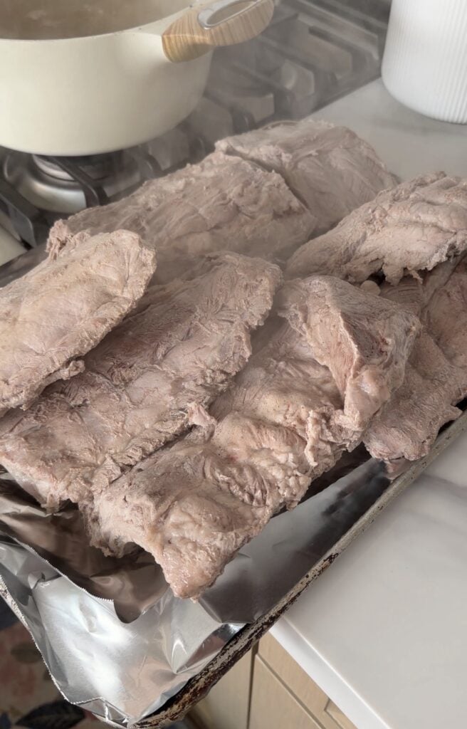 Pork ribs after being parboiled with onion apple cider vinegar and salt