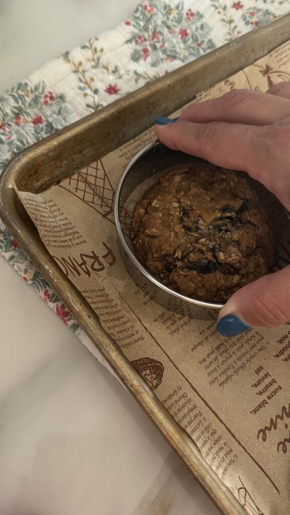 Using a round cookie cutter to shape oatmeal raisin cookies