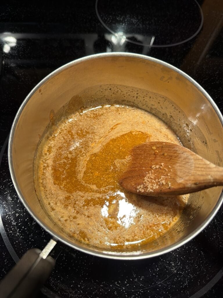 Homemade firecracker sauce made with butter, hot sauce, brown sugar, garlic, Worcestershire, and red pepper flakes.