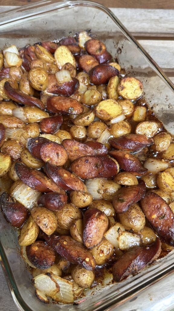 Firecracker Sausage and Potatoes arranged in a 9x13-inch casserole dish for roasting.