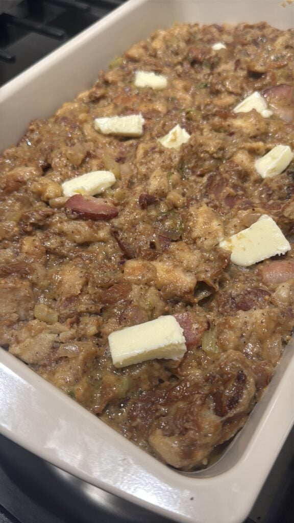 Hawaiian bread Stuffing for Ham topped with butter before baking