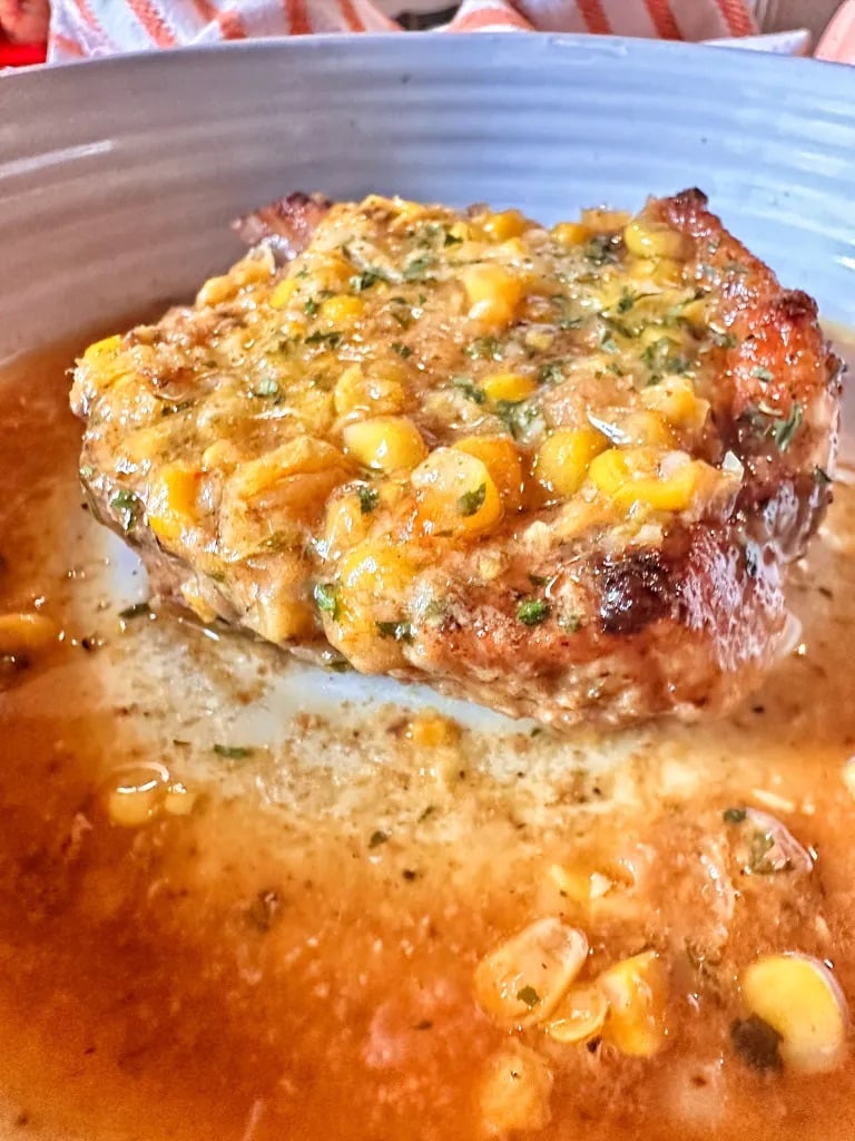 pork chops topped with a sweet corn topping and an au jus