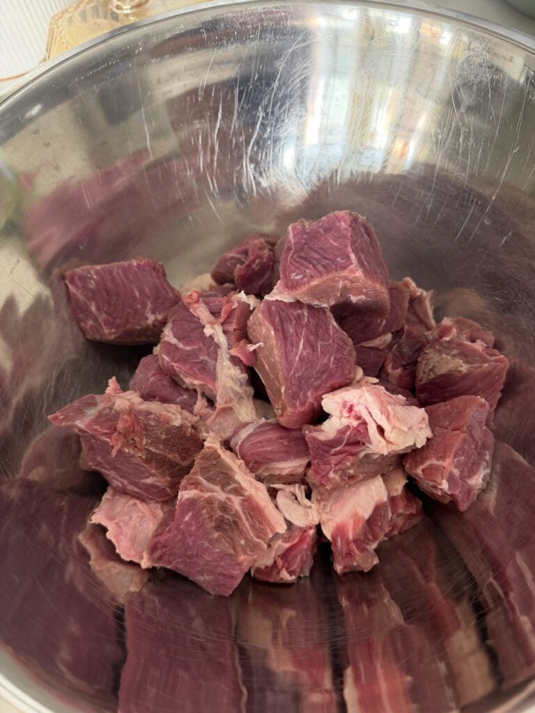 chuck roast cut into 2 inch pieces in a metal bowl