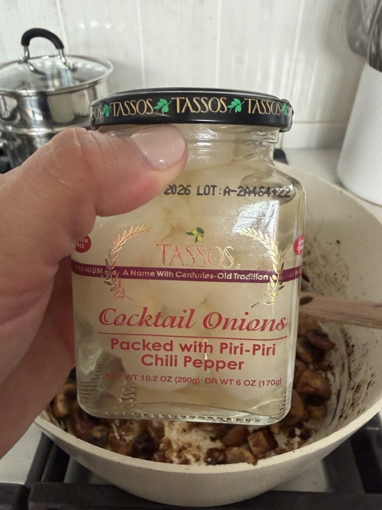 a jar of white cocktail onions in brine with red peppers