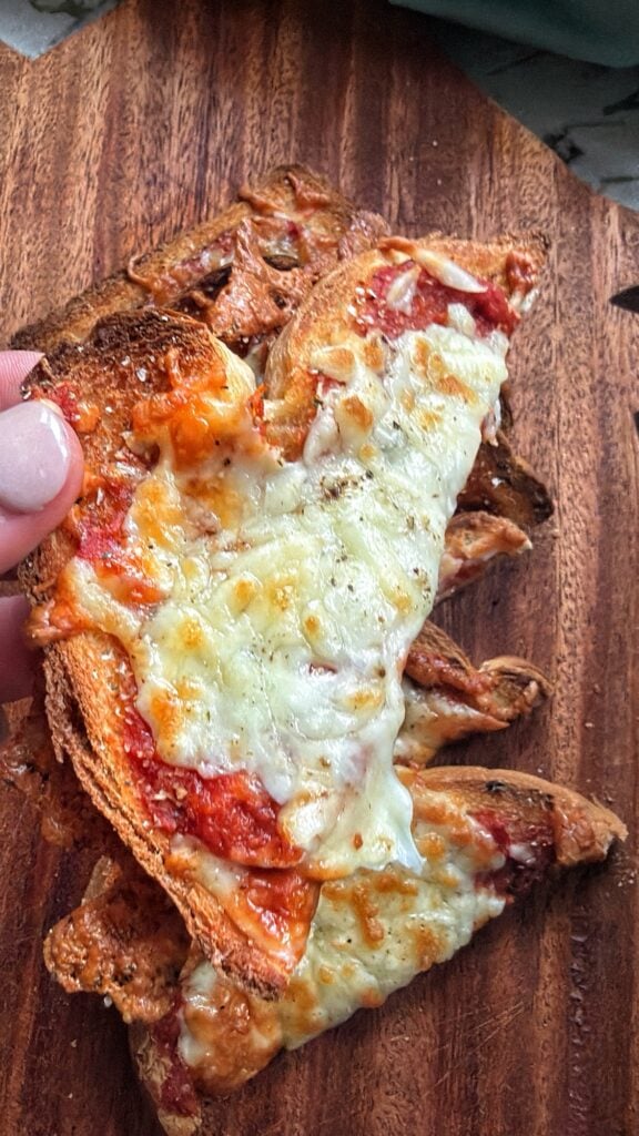 Easy pizza toast triangles topped with melted mozzarella and pizza sauce.