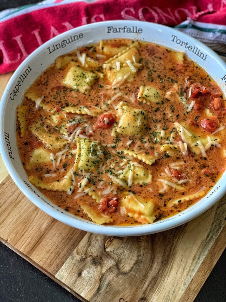 a bowl of ravioli in a broth with dried parsley