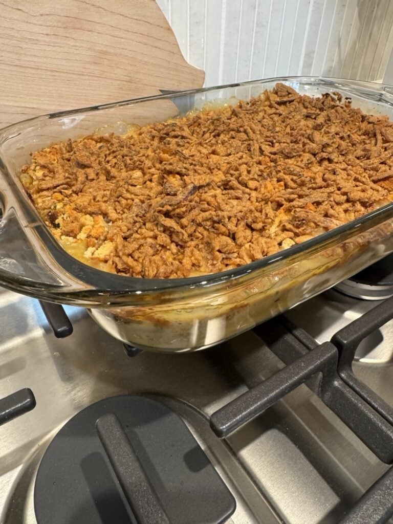A casserole dish with chicken and gravy topped with stuffing.