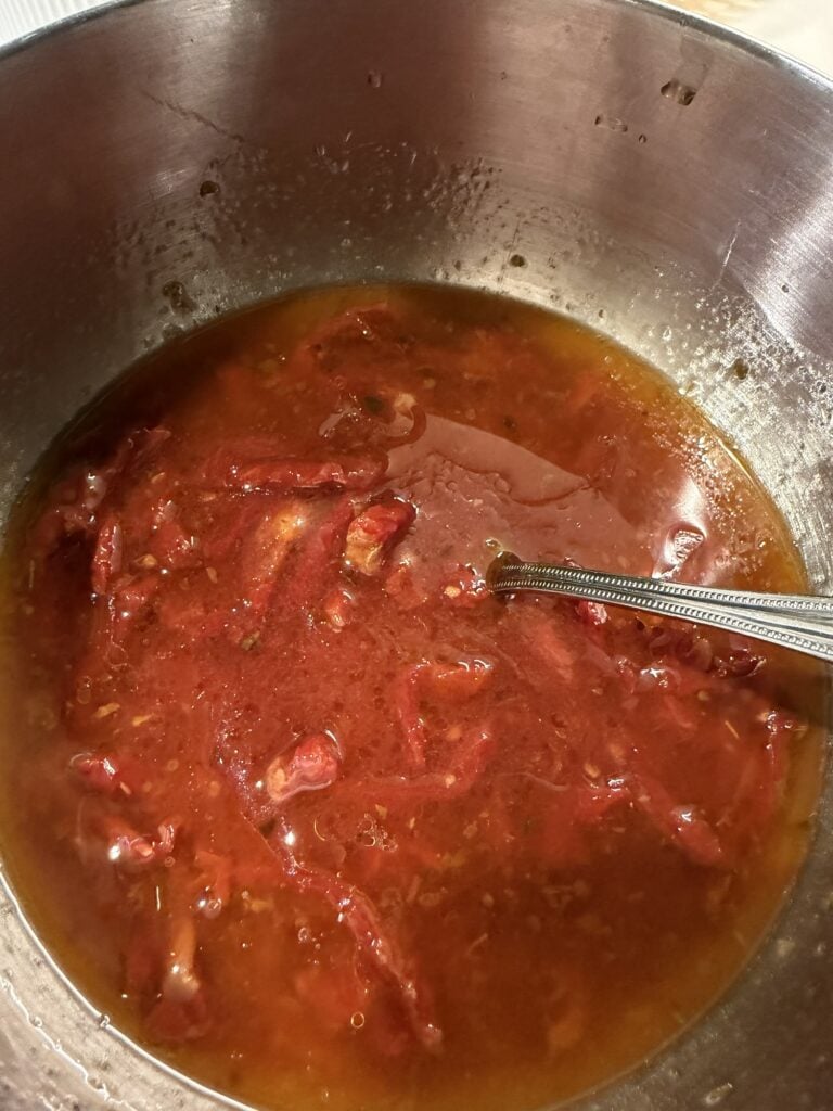 Thinly sliced sweet onions and sun-dried tomatoes marinating in an apple cider vinegar and herb dressing.