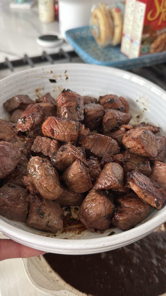 Seared sirloin steak bites tossed in a buttery soy sauce and chive pan sauce.