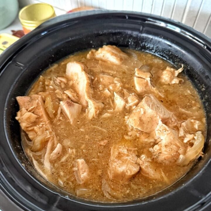 a slow cooker filled with sliced turkey in the gravy