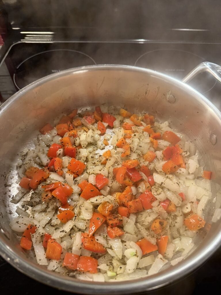 Diced sweet onion and red bell pepper sautéing in butter with Italian seasoning.