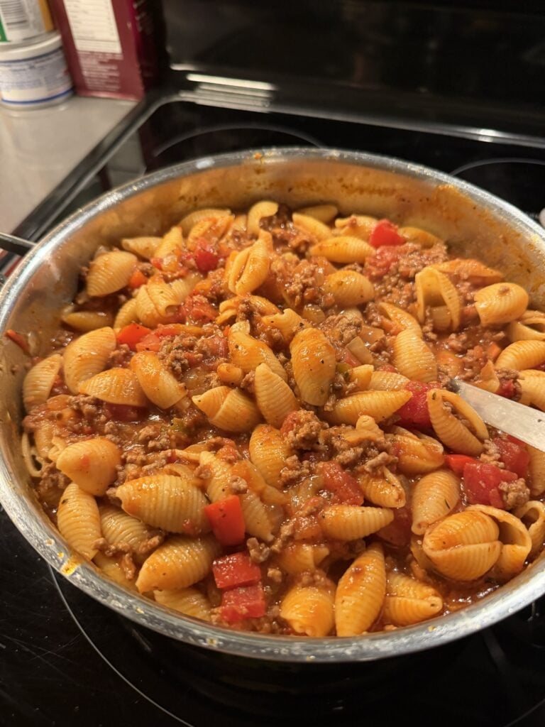 Shell pasta tossed in tomato meat sauce with ground beef, red bell pepper, and onion.