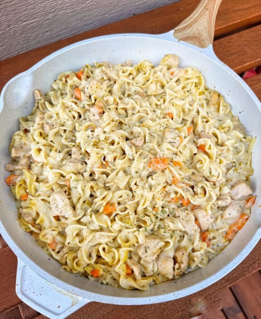 egg noodles with a chicken soup sauce in a skillet