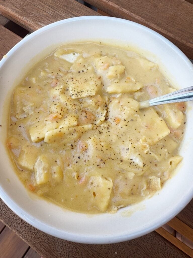 a bowl of creamy potato soup with crackers