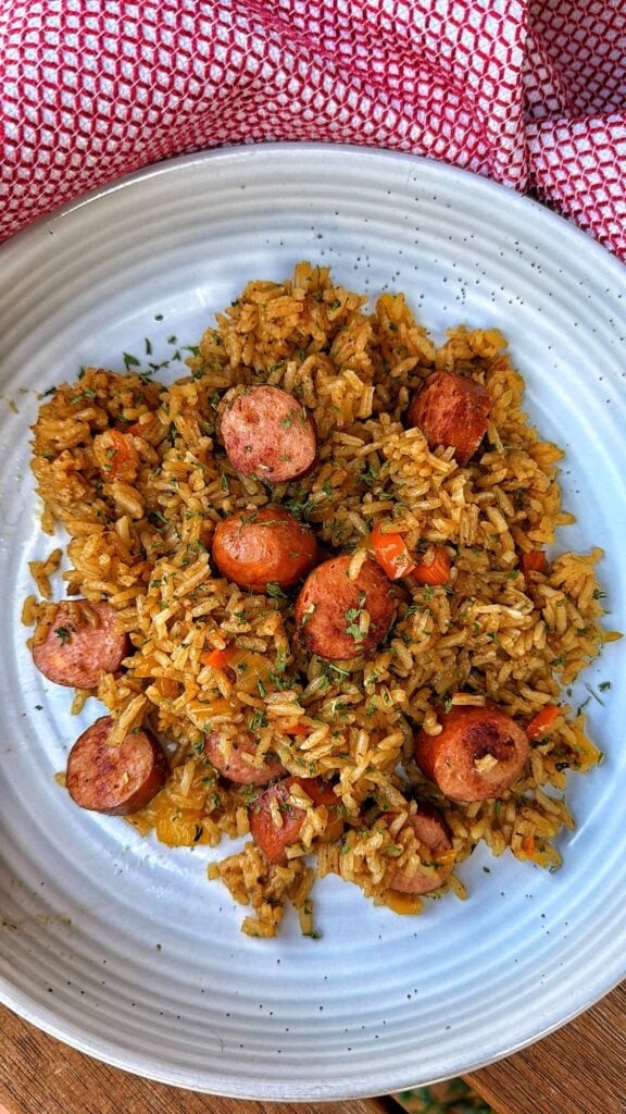 a plate of baked rice with cheddar brat slices baked with the rice
